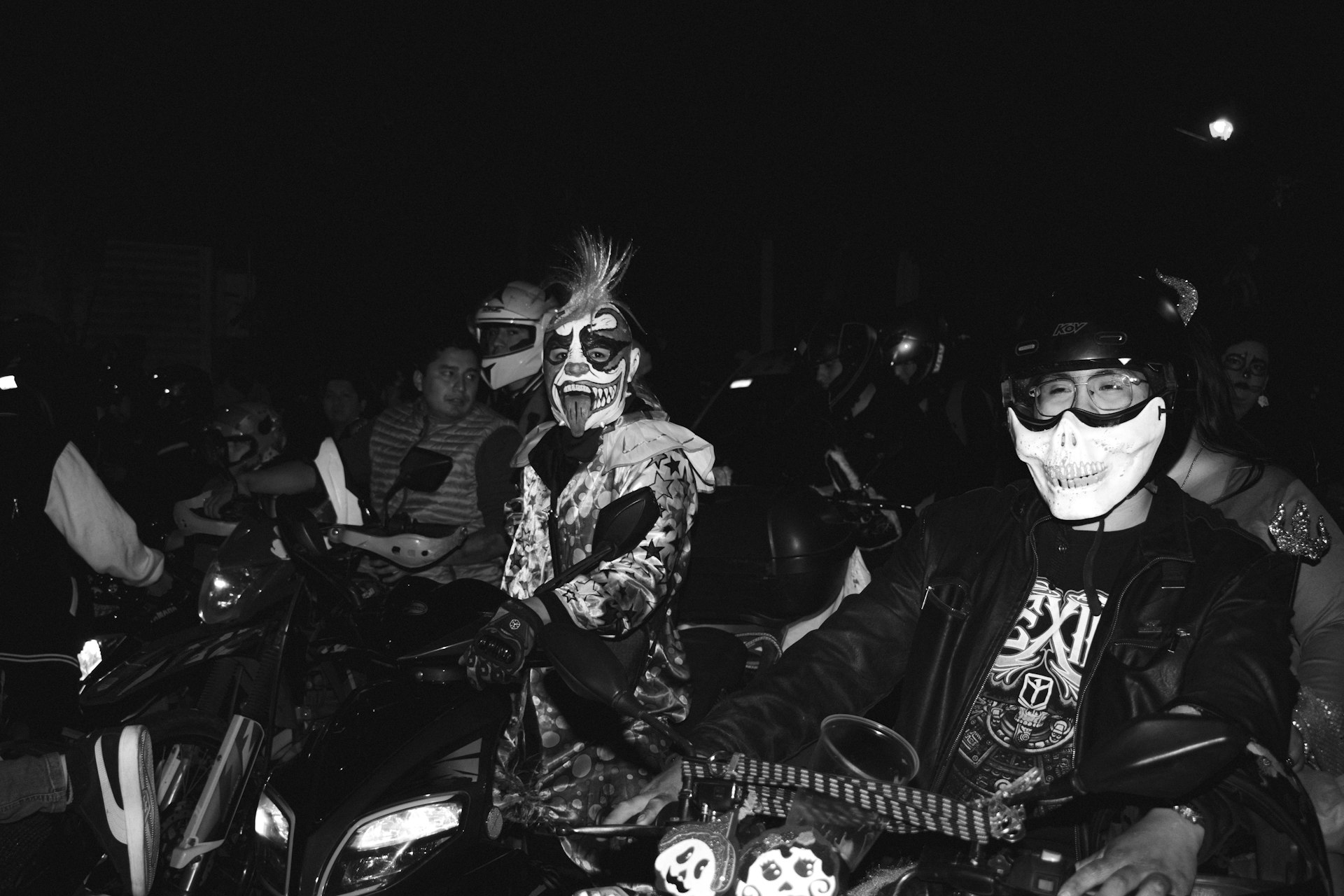 A black and white photo of a group of people on motorcycles